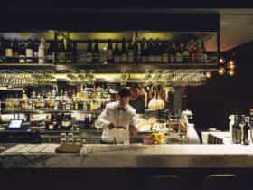 Barman pouring drinks at a marble bar