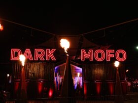 Fire and warm neon lights at the entrance gates to the Dark Mofo Winter Feast on Hobart waterfront