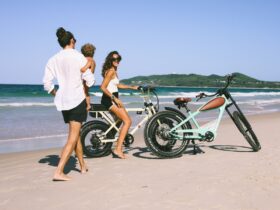 Family riding Ebikes on the beach in Byron Bay. Vintage cruiser style bikes views of Byron Bay.